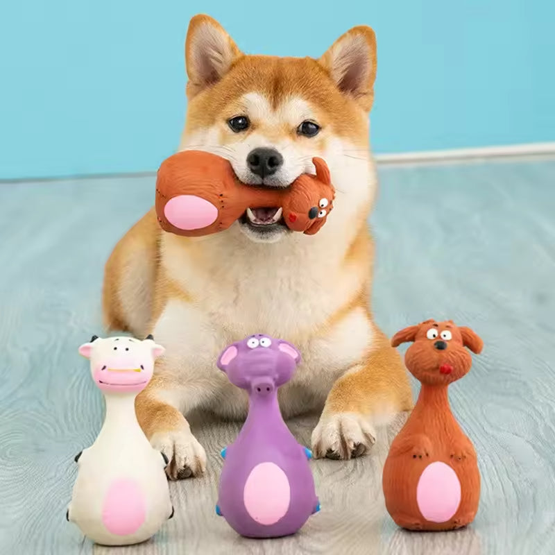 Shiba Inu dog playing with colorful animal-shaped dog toys on wooden floor
