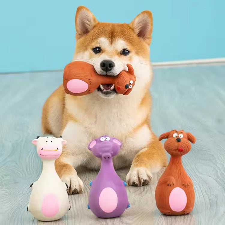 Shiba Inu dog playing with colorful animal-shaped dog toys on wooden floor